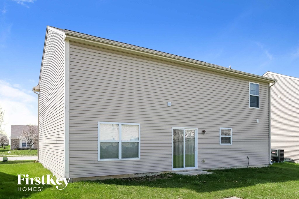 the exterior of a home with a grey siding    and a lawn