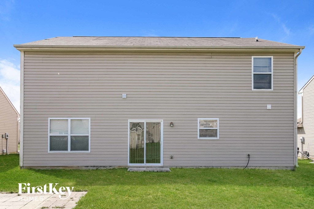 a side view of a house with a yard and grass