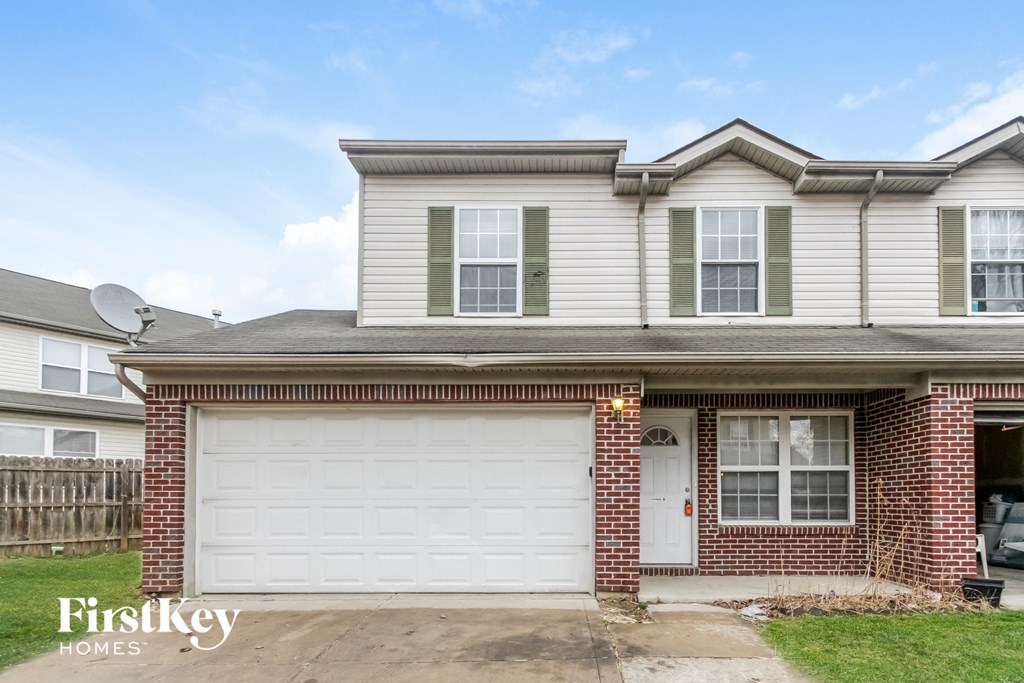 A two-story house with a garage is for sale.