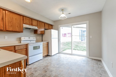 A kitchen with wooden cabinets and a white fridge.