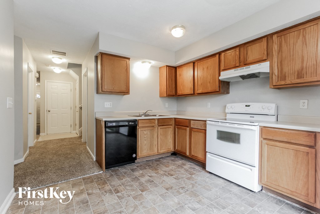 A kitchen with wooden cabinets and a white dishwasher.