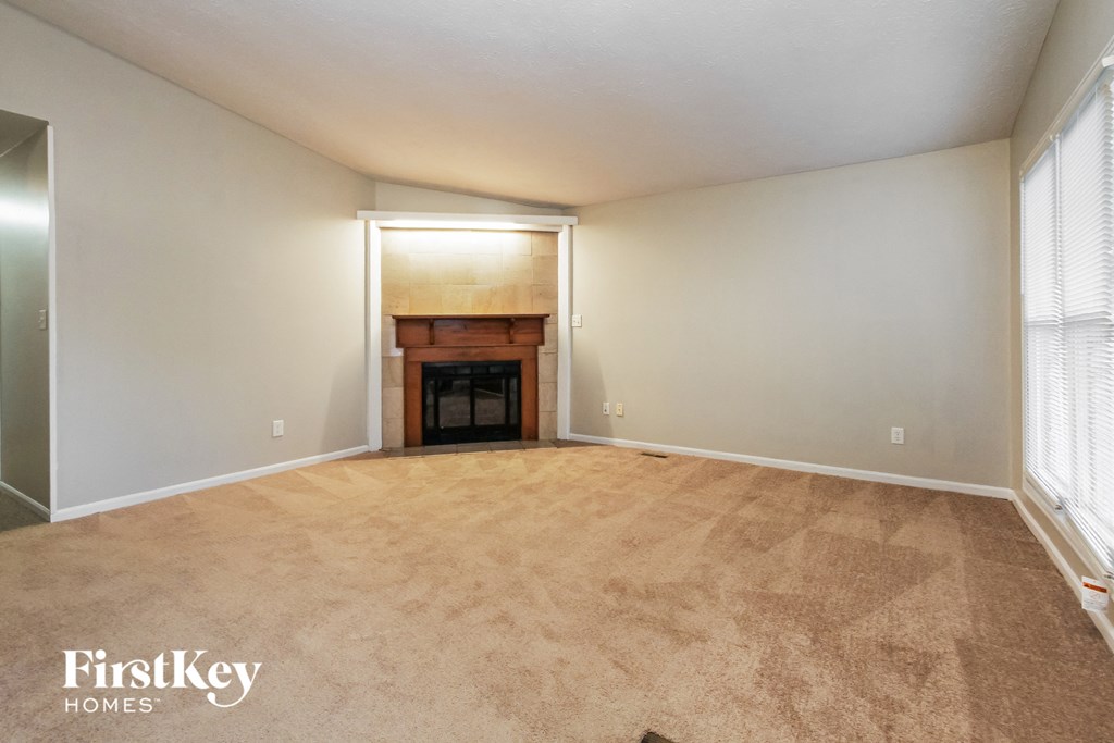 the living room of an empty house with a fireplace