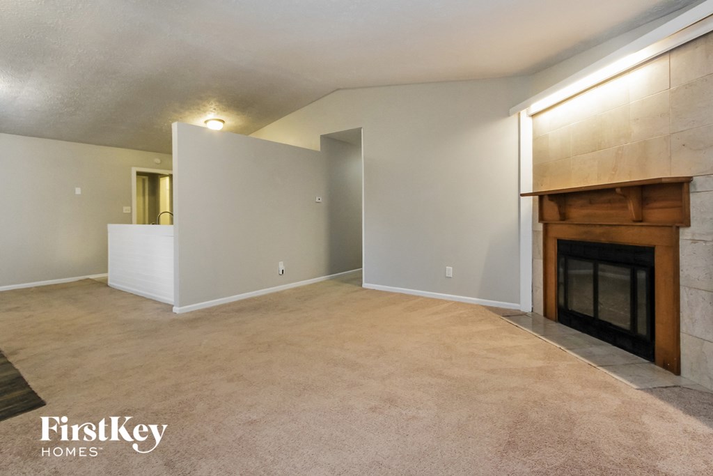 a living room with a fireplace and a carpeted floor