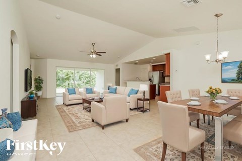 A spacious living room with a dining table set up in the middle.
