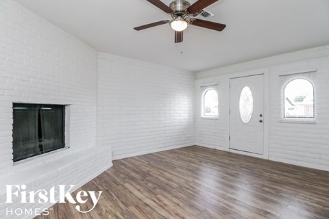 A room with a fireplace and a ceiling fan.
