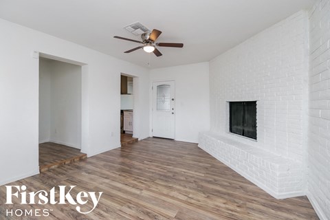 A room with a fireplace and a ceiling fan.