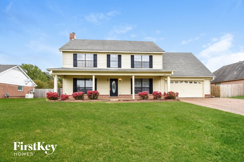 A two-story house with a front yard and a garage.