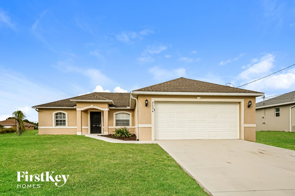 a beige house with a driveway and a garage door