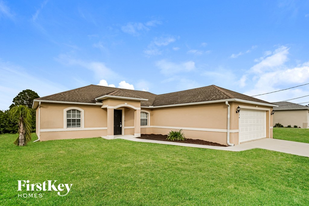 a beige house with a lawn and a garage