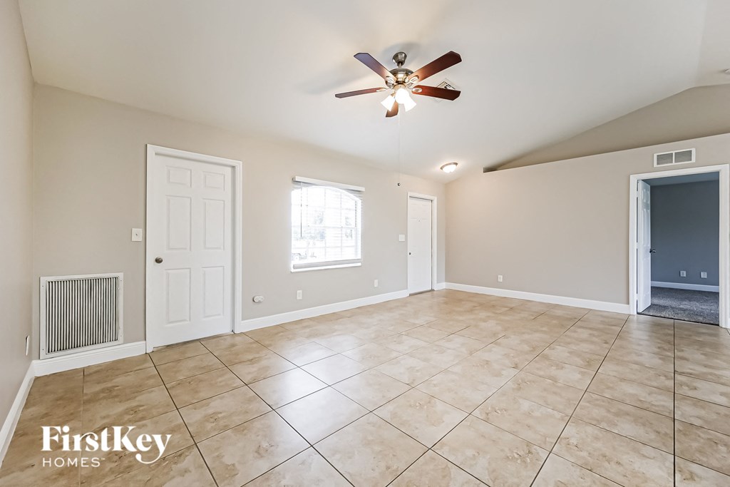 a clean and empty living room with a ceiling fan