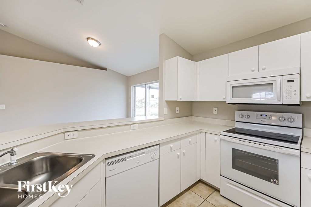 a white kitchen with white appliances and white cabinets