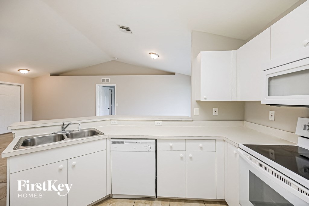a white kitchen with white cabinets and white appliances