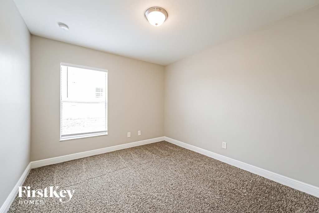 an empty room with carpet and a window
