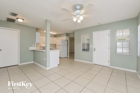 A spacious room with a ceiling fan and tiled flooring.