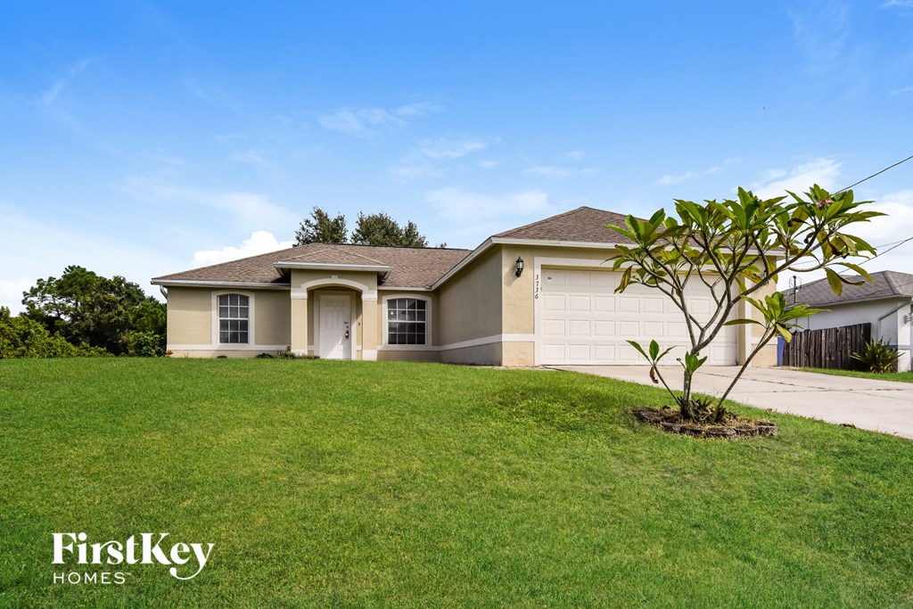 a house with a lawn and a tree in front of it