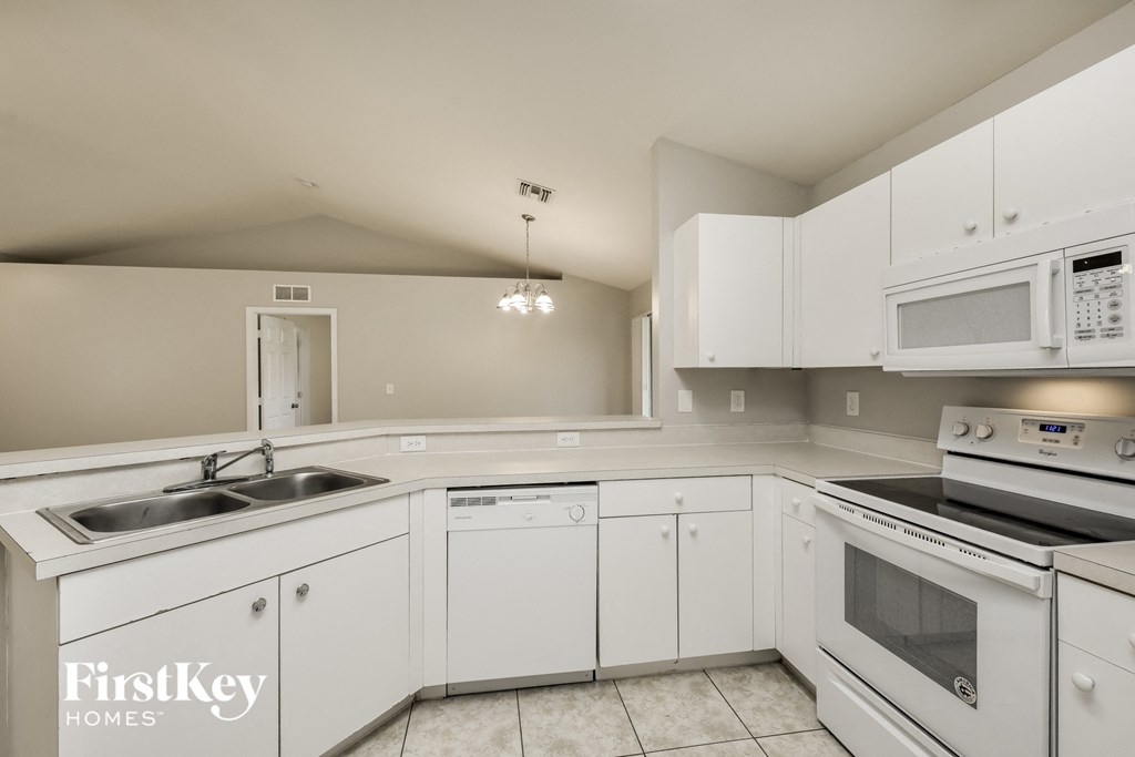 a white kitchen with white appliances and white cabinets
