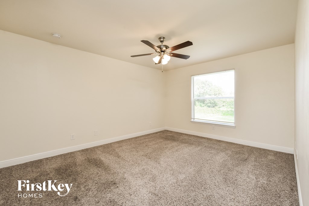 a living room with carpet and a ceiling fan