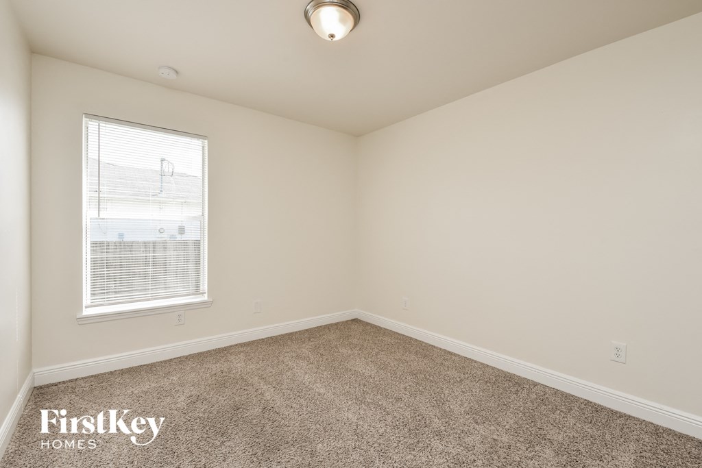 a bedroom with carpeted flooring and a window