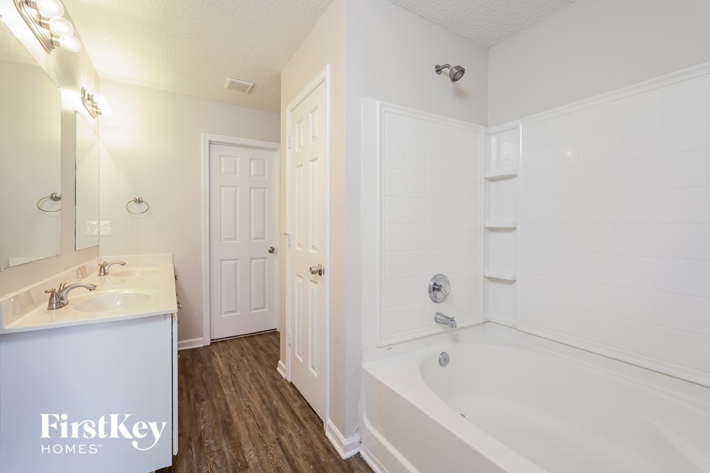 a bathroom with a tub and a sink and a mirror