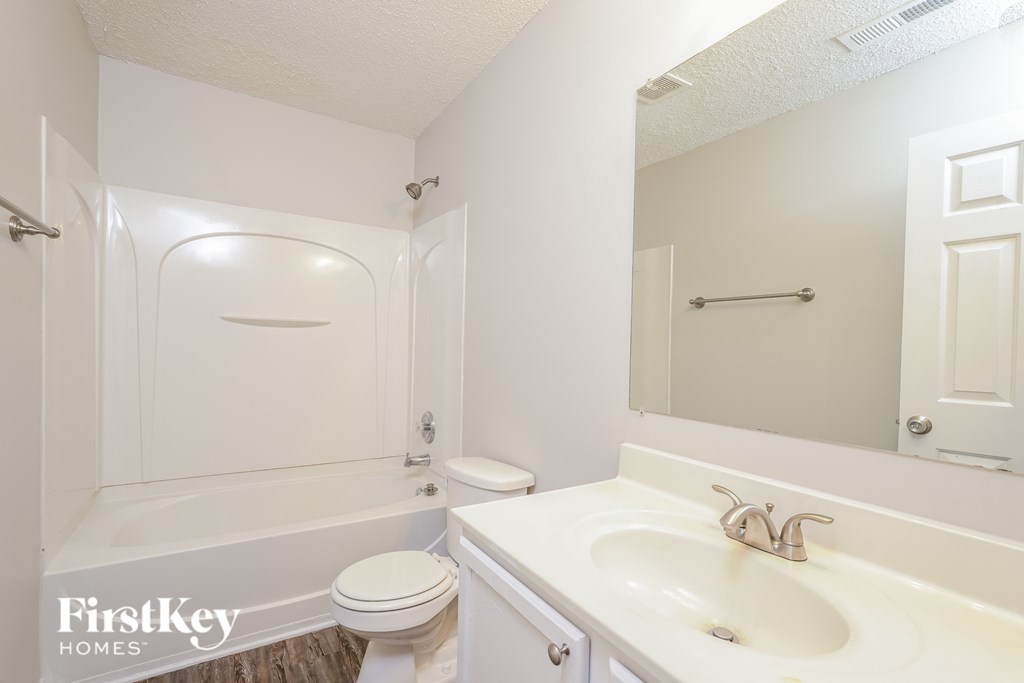 a bathroom with a sink and a toilet and a bath tub