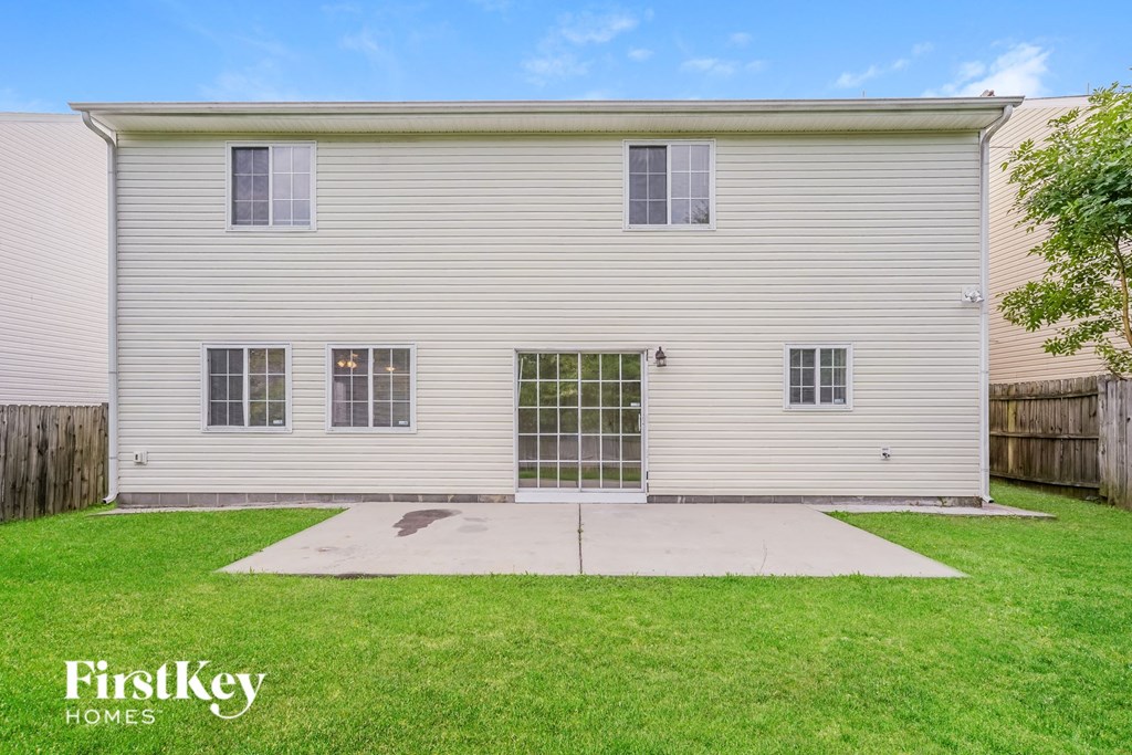 the front of a white house with a yard and grass