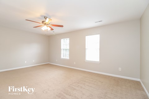 a bedroom with a ceiling fan and a carpeted floor