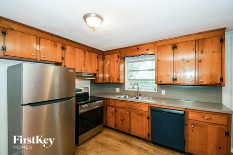 A kitchen with wooden cabinets and a stainless steel refrigerator.