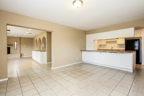 a large kitchen and living room with tiled flooring and a counter top