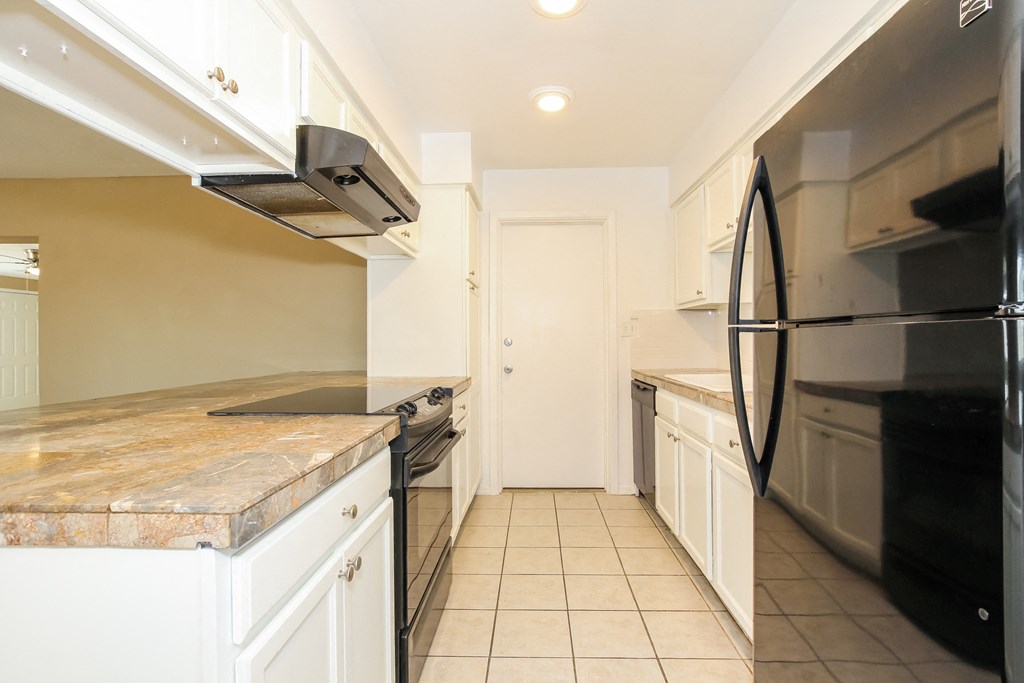 a kitchen with stainless steel appliances and white cabinets