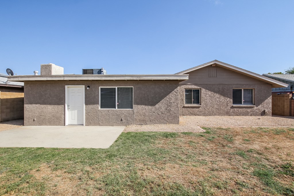 a brown brick house with a white door and a lawn