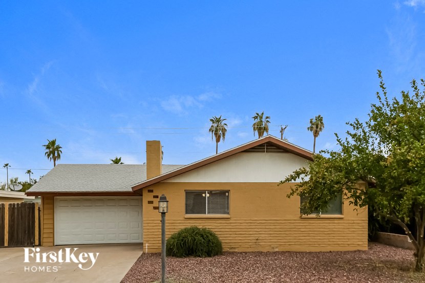 a yellow house with palm trees in the background