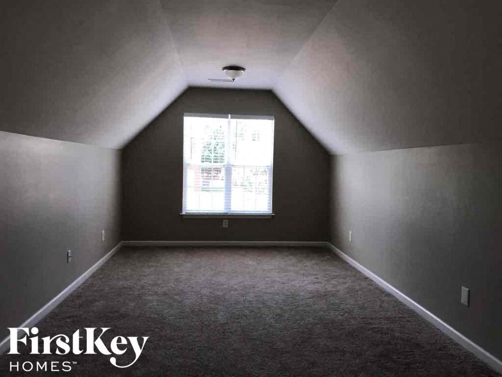 an empty attic room with a window
