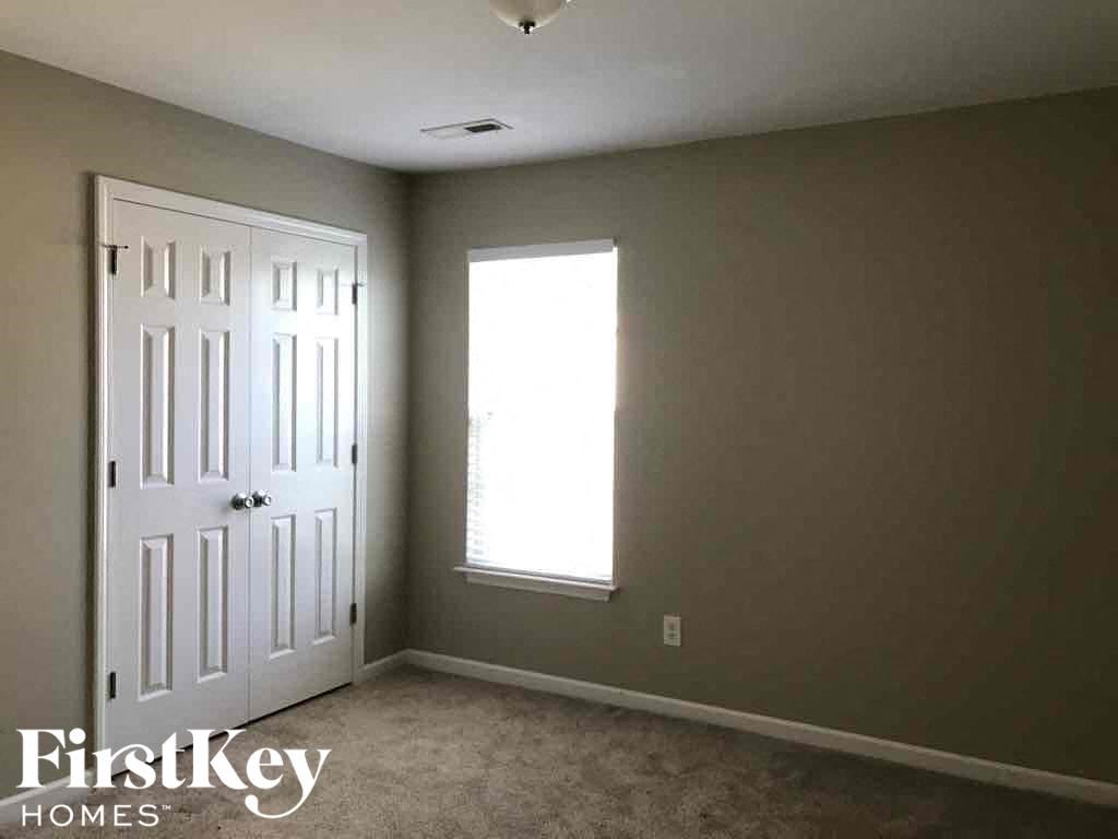 an empty room with a white door and a window