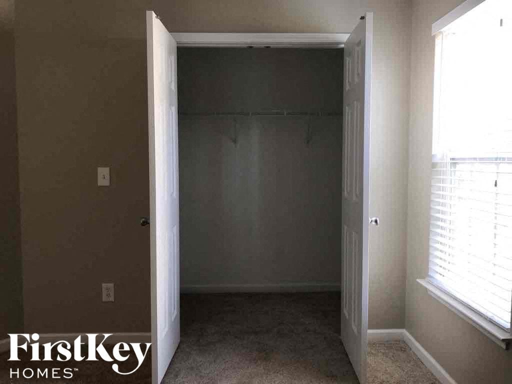 an empty room with a closet and a window