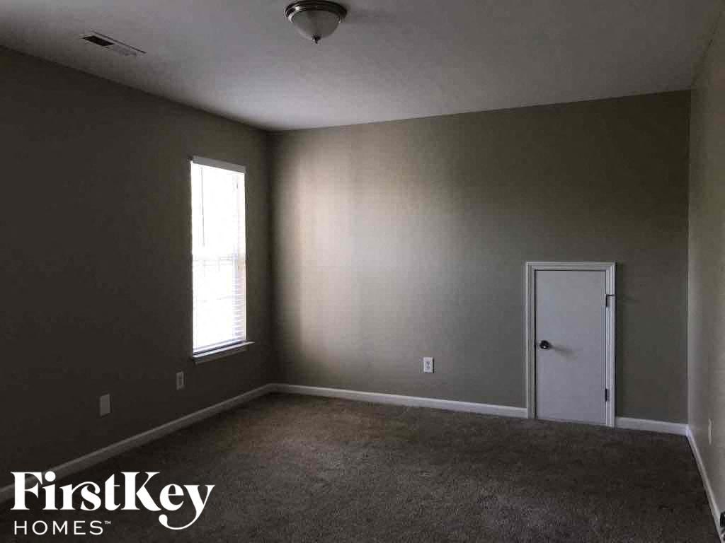 an empty room with a white door and a window