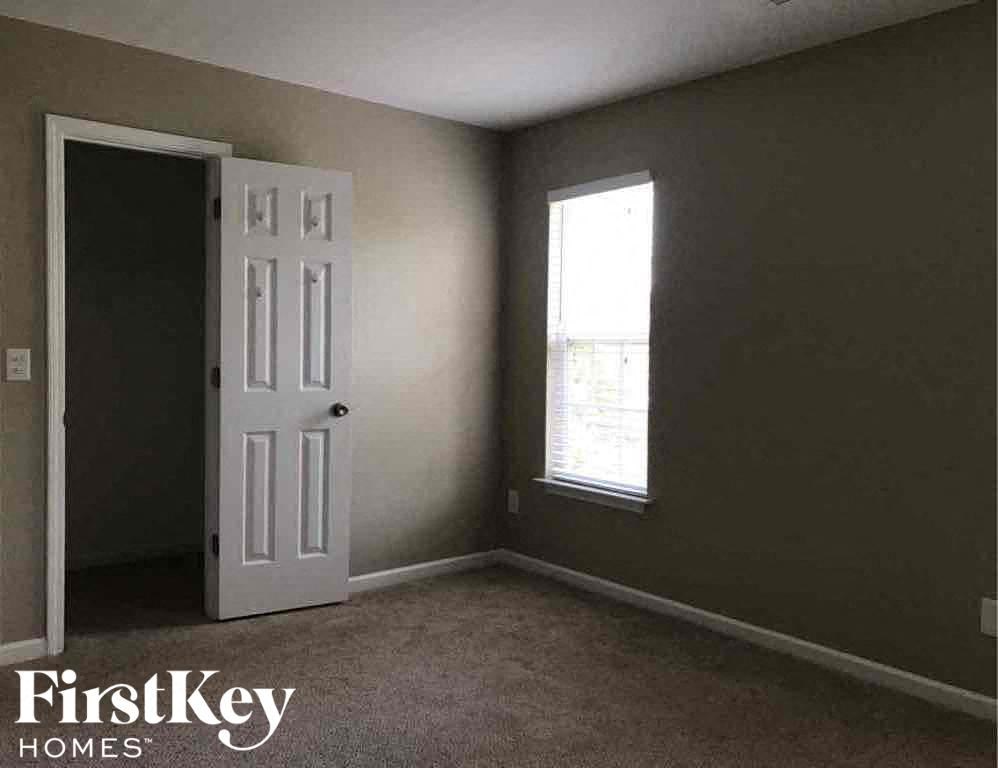 an empty room with a white door and a window