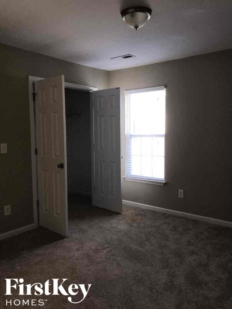 an empty room with a door and a window and a closet