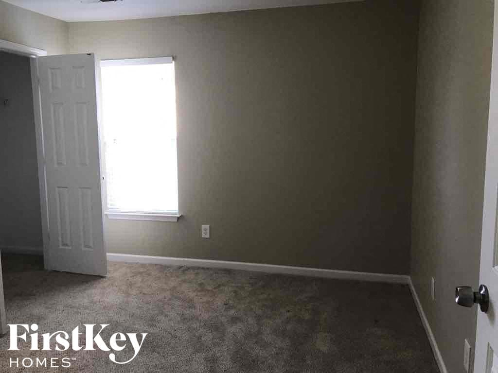 an empty room with a white door and a window