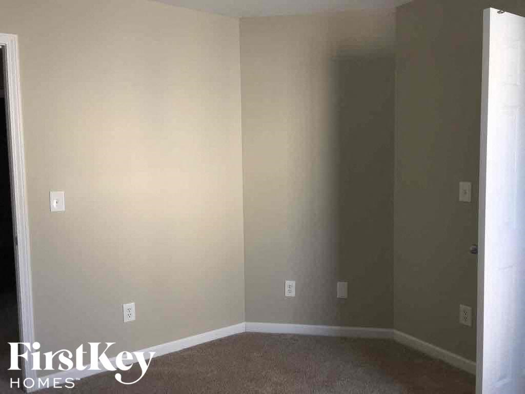 an empty room with white walls and a gray carpet