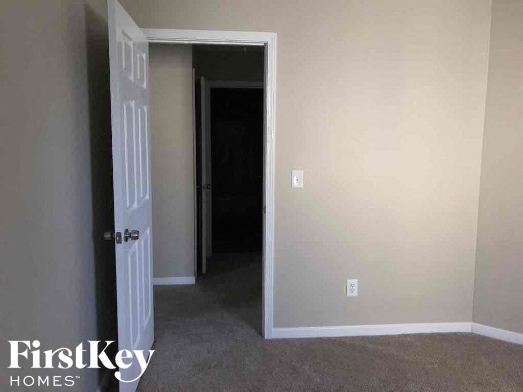 a room with a door open to a hallway and a closet