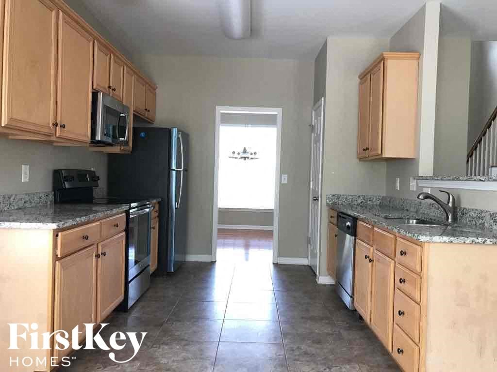an empty kitchen with wooden cabinets and stainless steel appliances