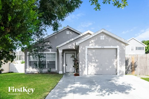 a gray house with a white garage door and a lawn