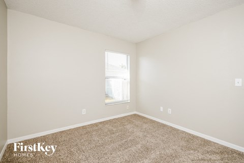 a bedroom with carpet and a window