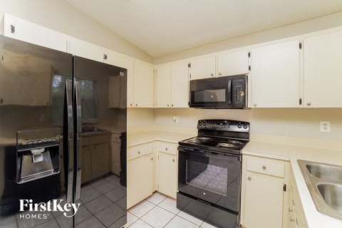 a kitchen with black appliances and white cabinets