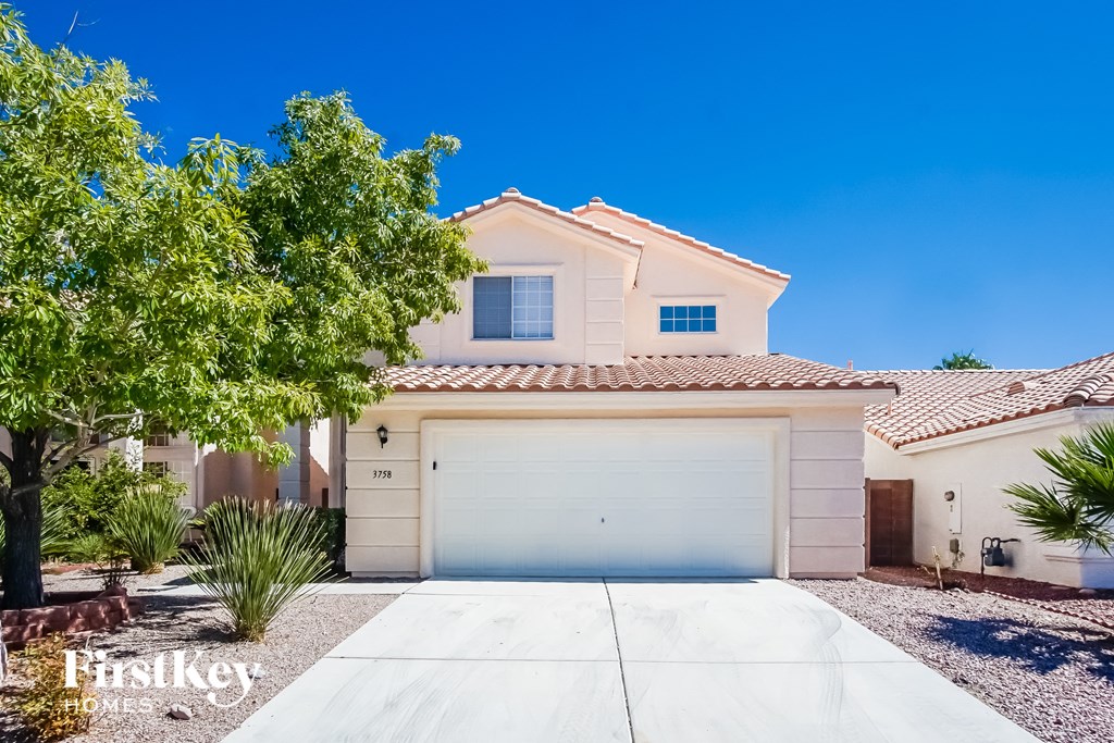 a white house with a garage door in front of it