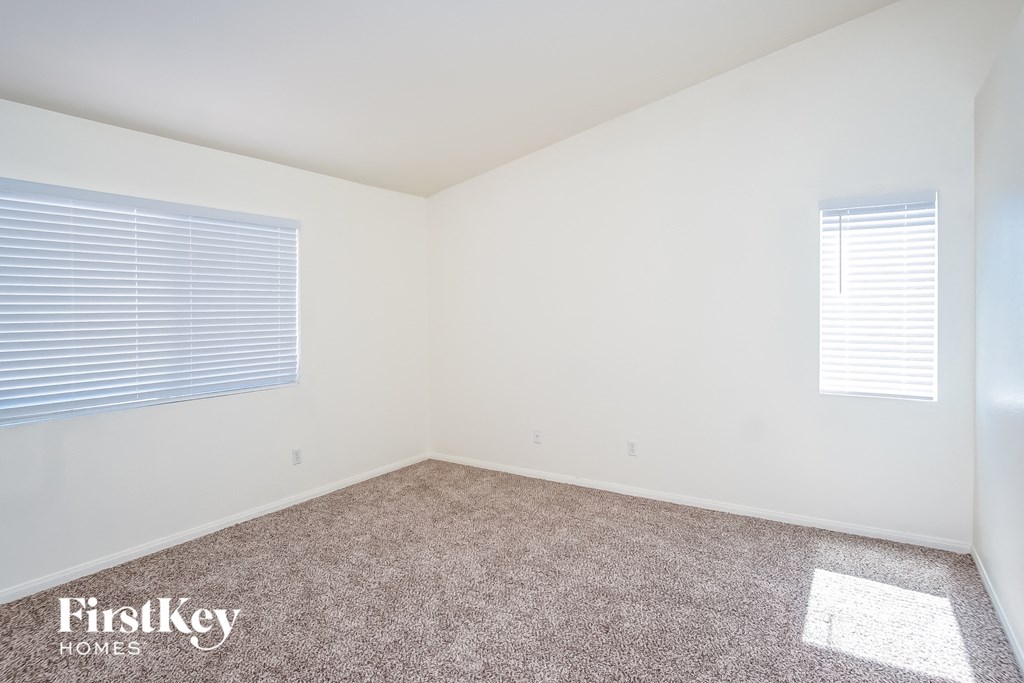 a bedroom with a carpeted floor and a window