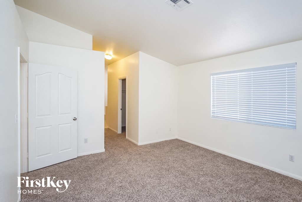 a bedroom with white walls and carpet and a white door
