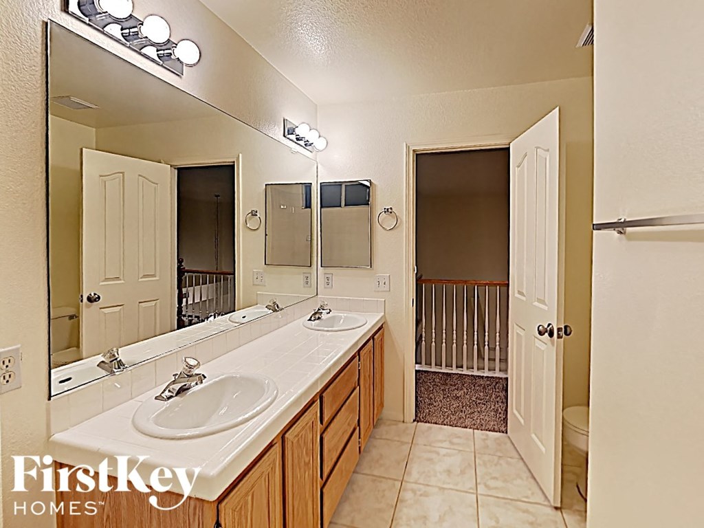 a bathroom with two sinks and a large mirror