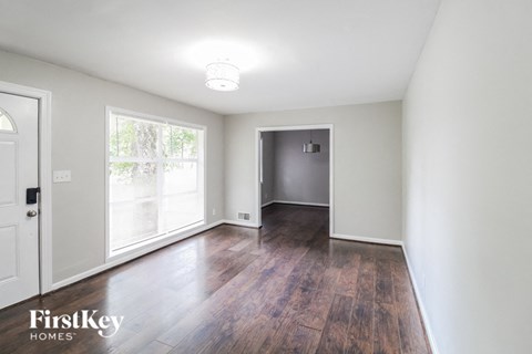 an empty living room with white walls and wood floors