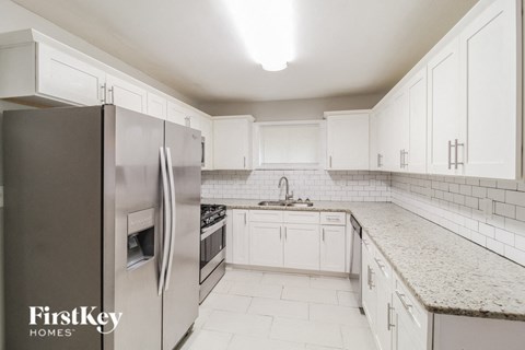 a kitchen with white cabinets and a stainless steel refrigerator